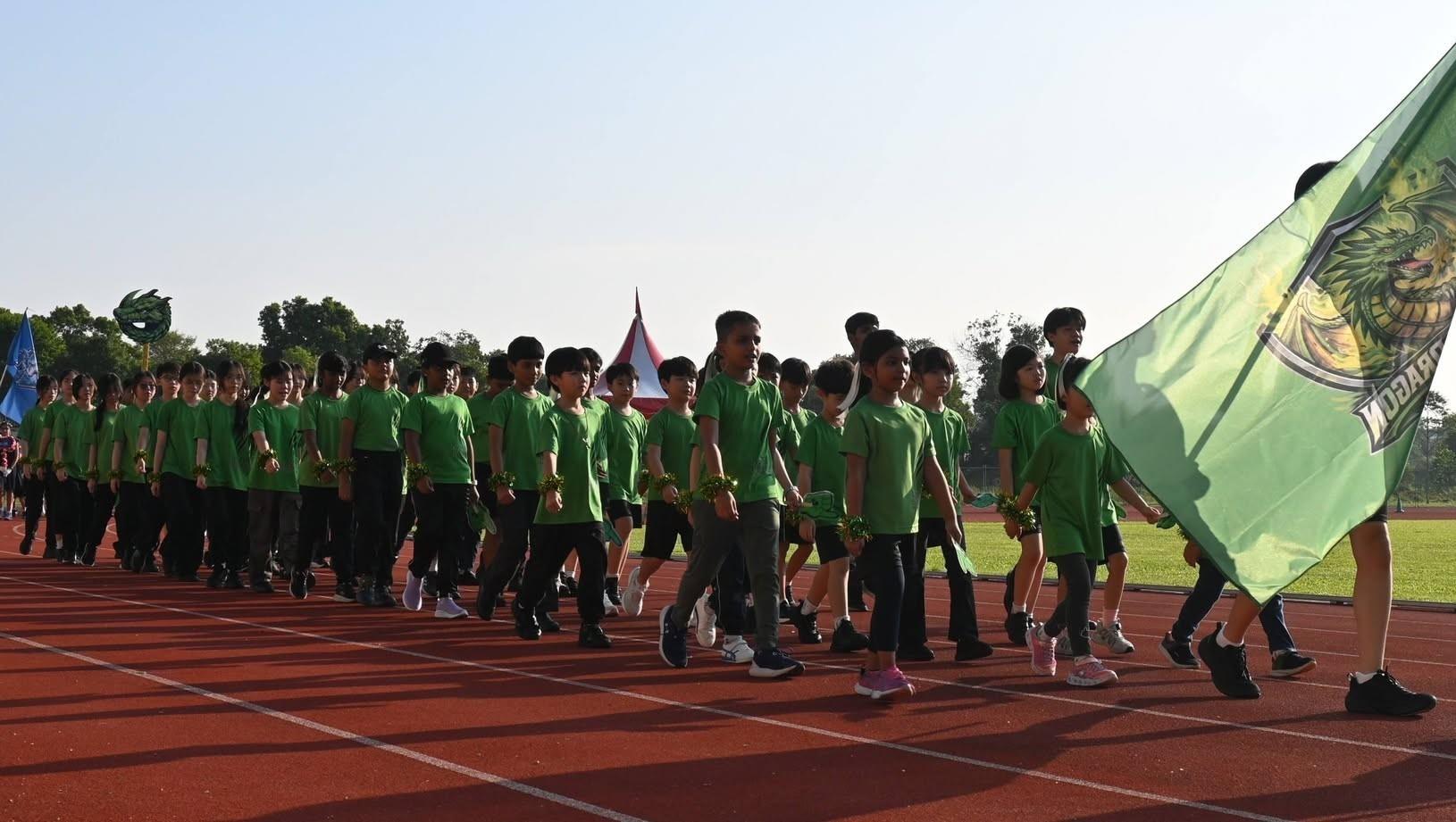 Green House marching in formation on the track at Sports Day